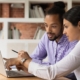 Two people working at laptop