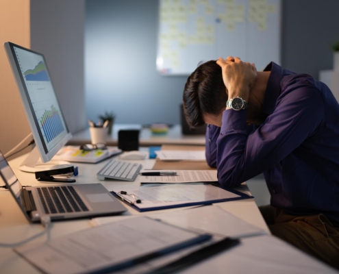 Person stressed at computer desk