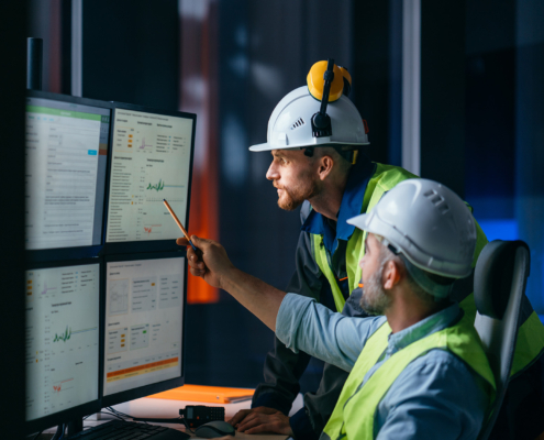 Two manufacturing workers looking at computer
