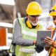Two workers in manufacturing looking at tablet